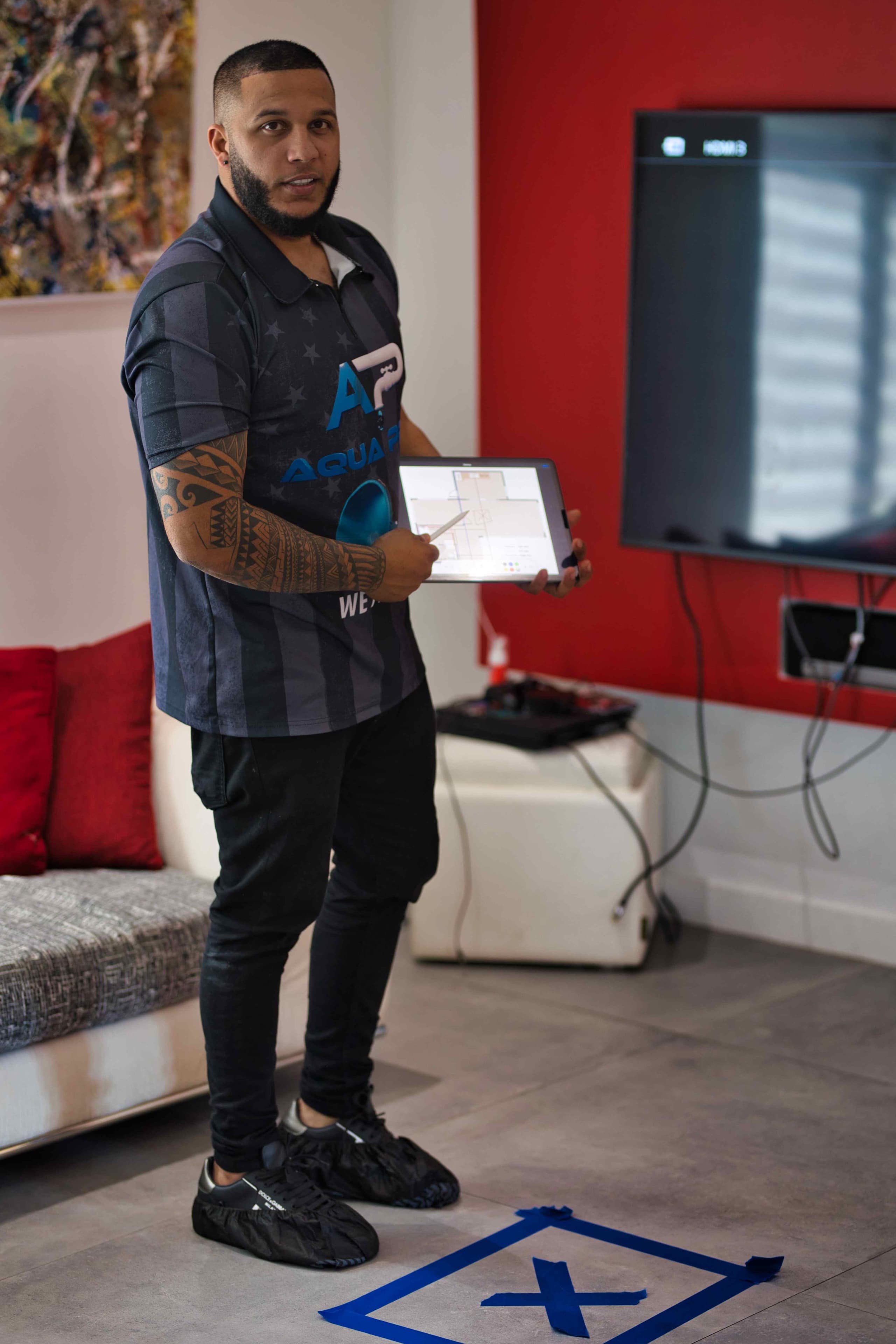 Aqua Pro technician holding a tablet inside a home