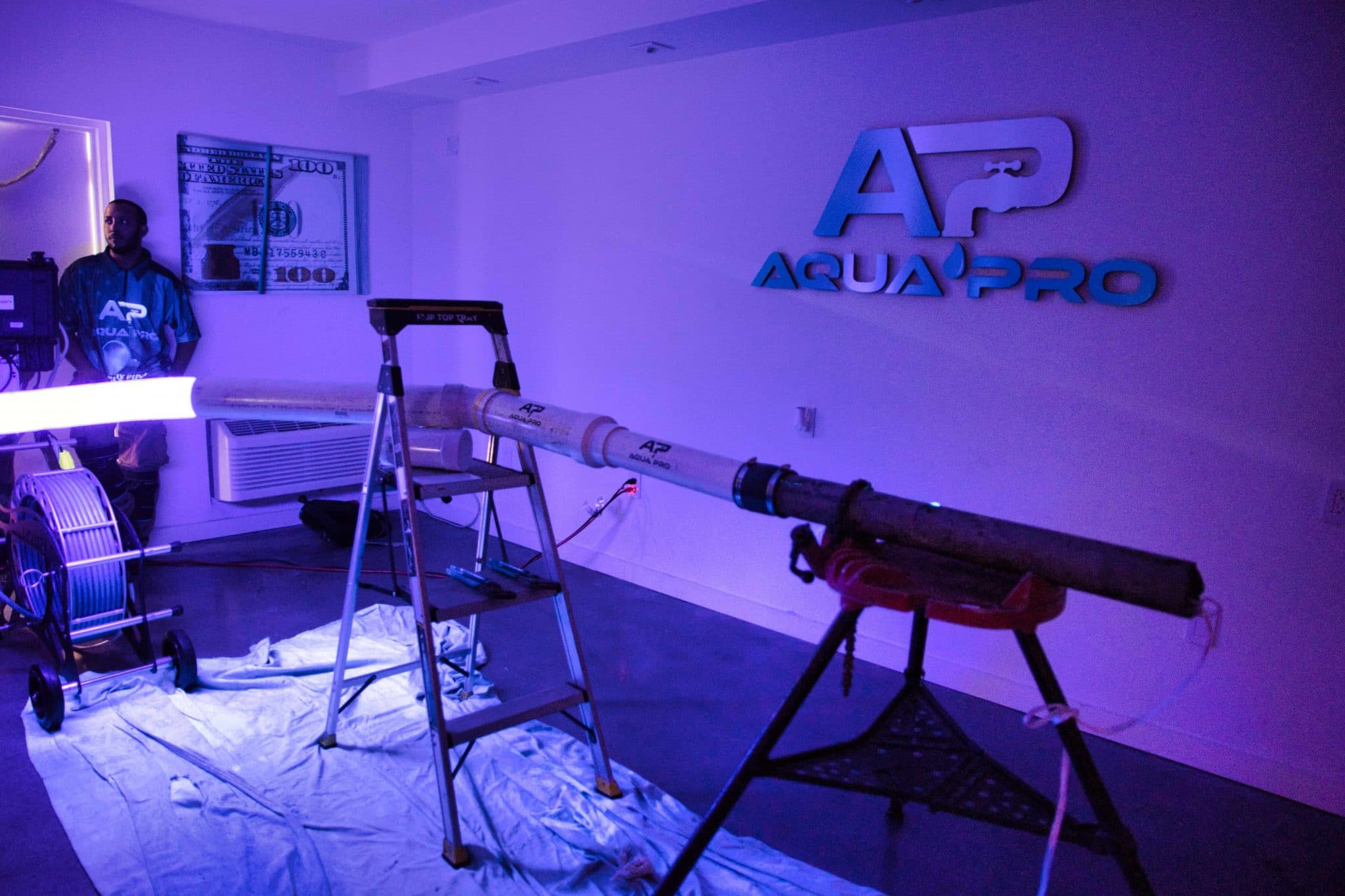 A LightRay UV cure glowing through a clear test pipe on a pipe stand in the Aqua Pro lab